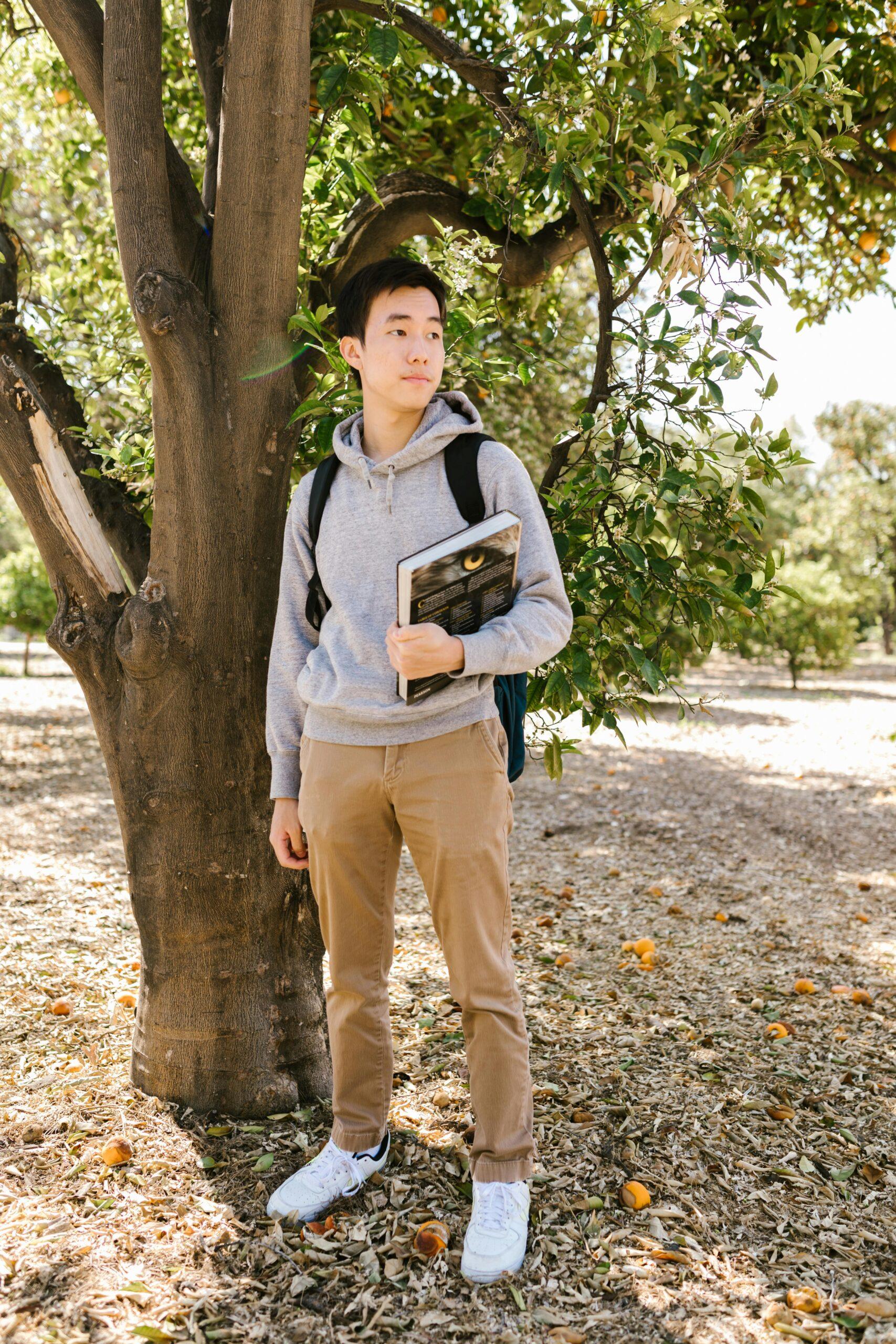 Asian boy holding textbook