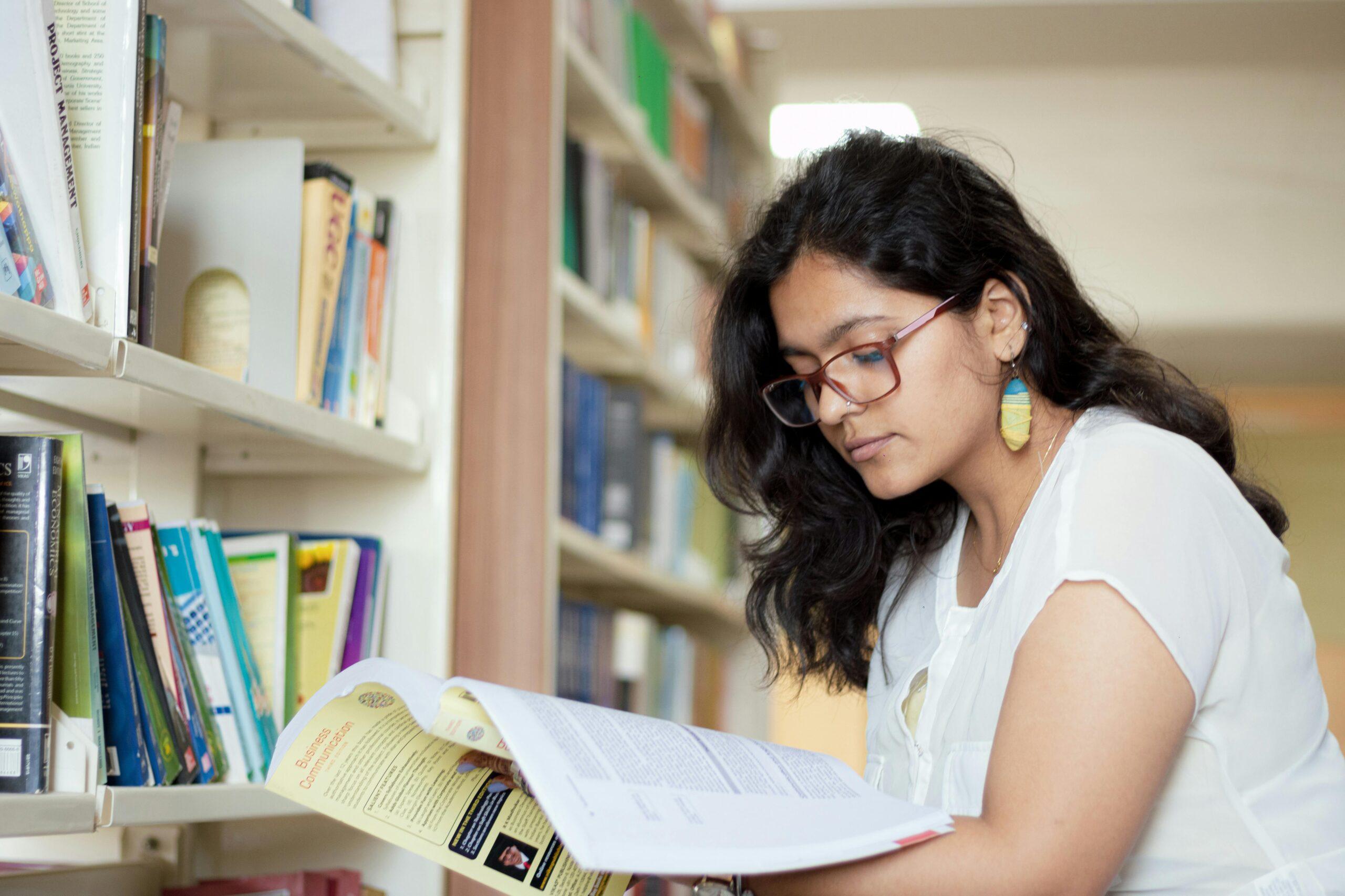 woman reading a book in a college library